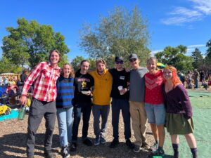 Alumni pose at Harvest Festival with teachers.